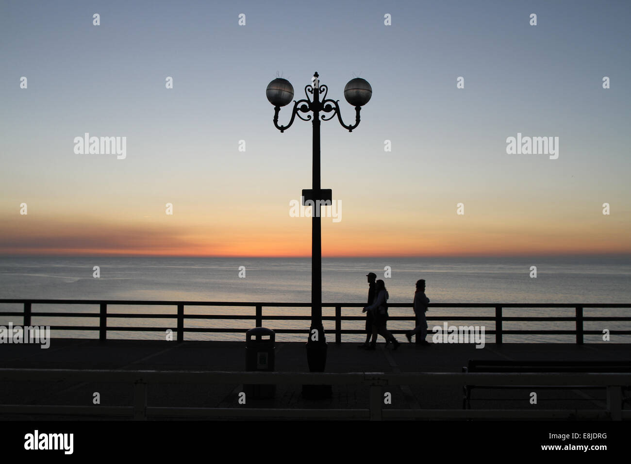 Silhouetten, walking am Strand bei Sonnenuntergang. Stockfoto