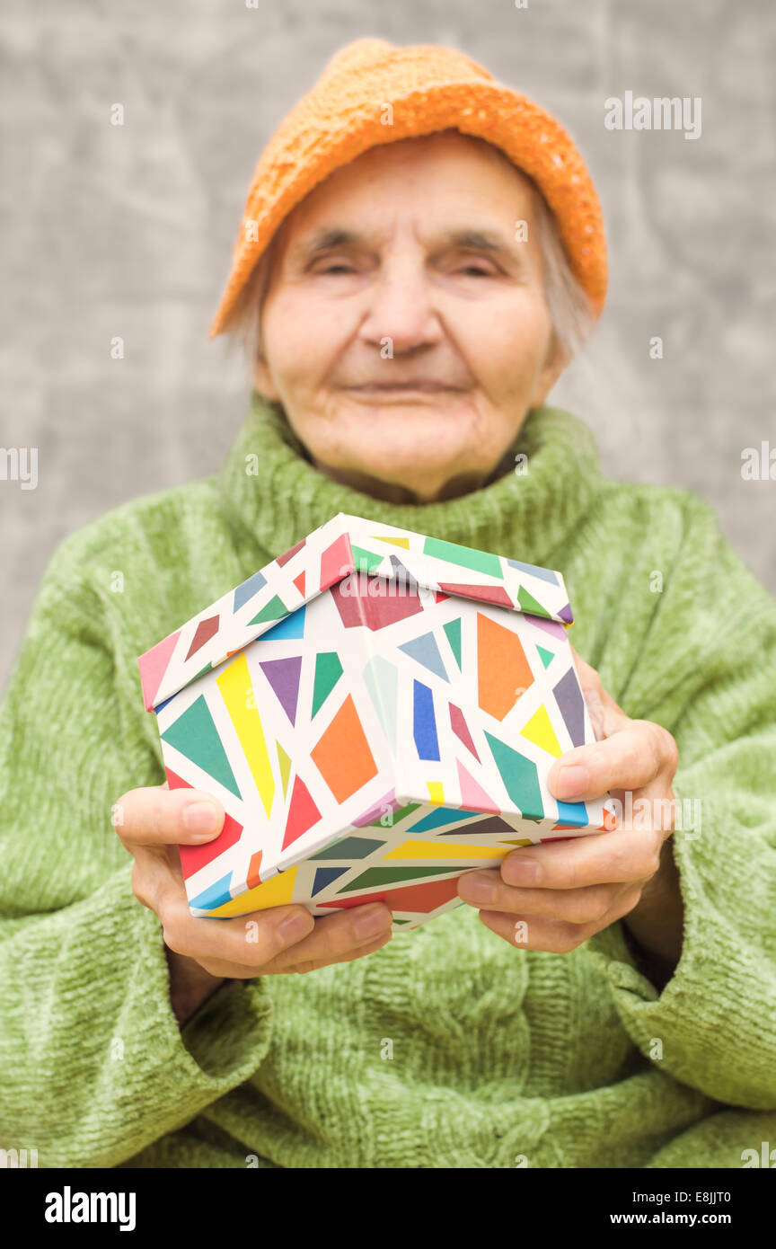 Ältere Frau mit einer Geschenkbox geliefert. Selektiven Fokus auf Geschenk. Stockfoto