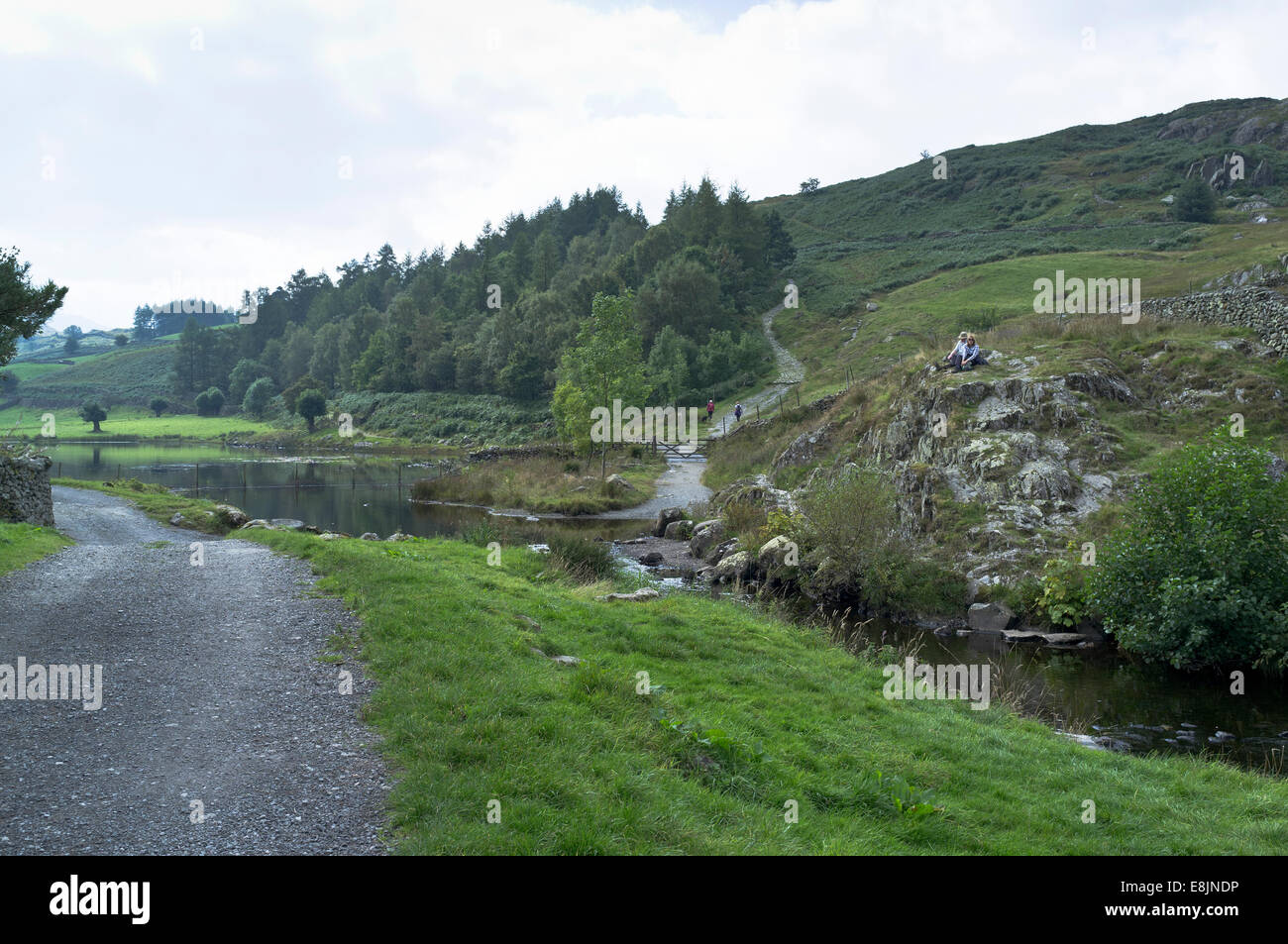 dh paar Watendlath Tarn WATENDLATH SEENPLATTE Wanderer zu Fuß Hügel Fußweg entspannen Stockfoto