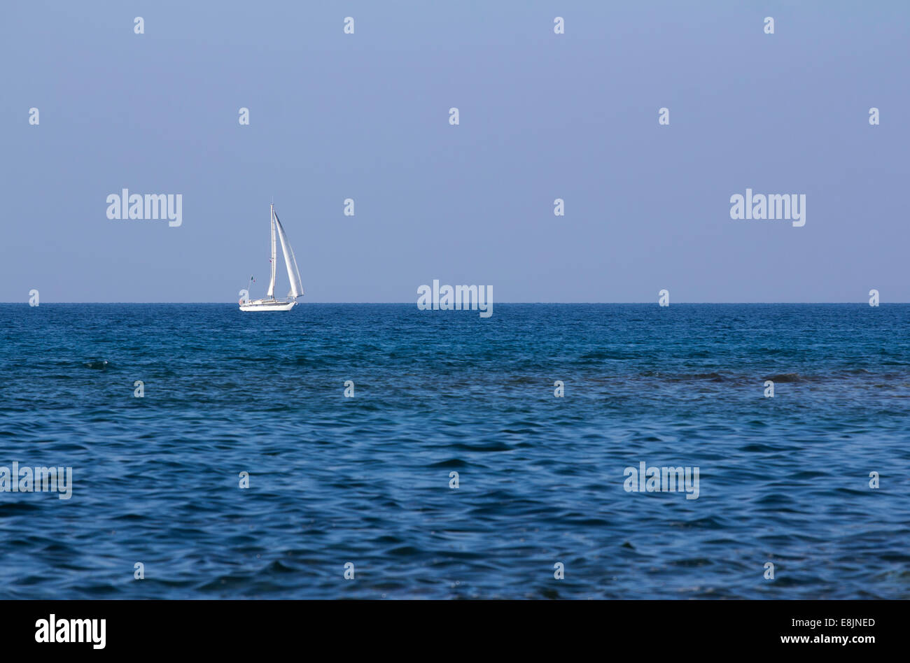 Segelboot auf das offene blaue Meer bei Sonnenuntergang. Stockfoto