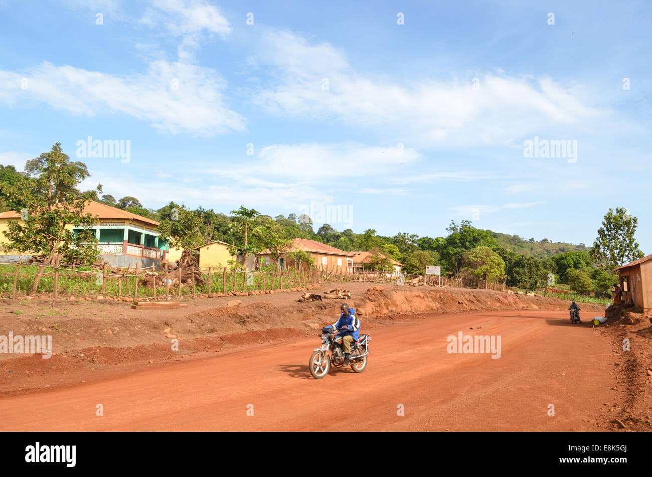 Ein Motorradfahrer fahren die Feldwege in den reinen Himmel der Fouta Djalon Hügel von Guinea, Westafrika Stockfoto