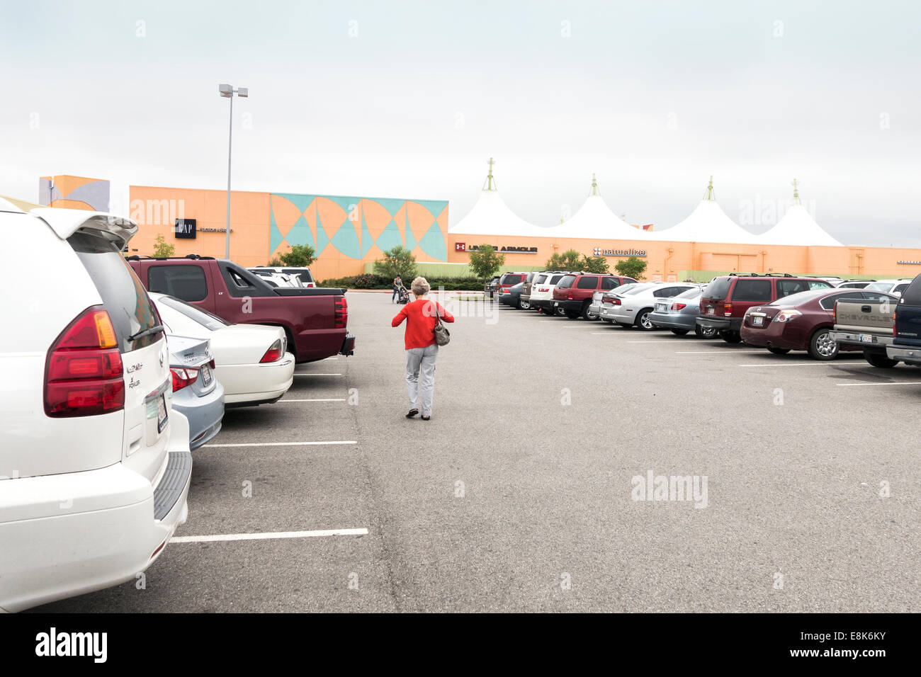 Das Outlet Shoppes in Oklahoma City, Oklahoma, USA zeigt Shopper und die Mall vom Parkplatz. Stockfoto