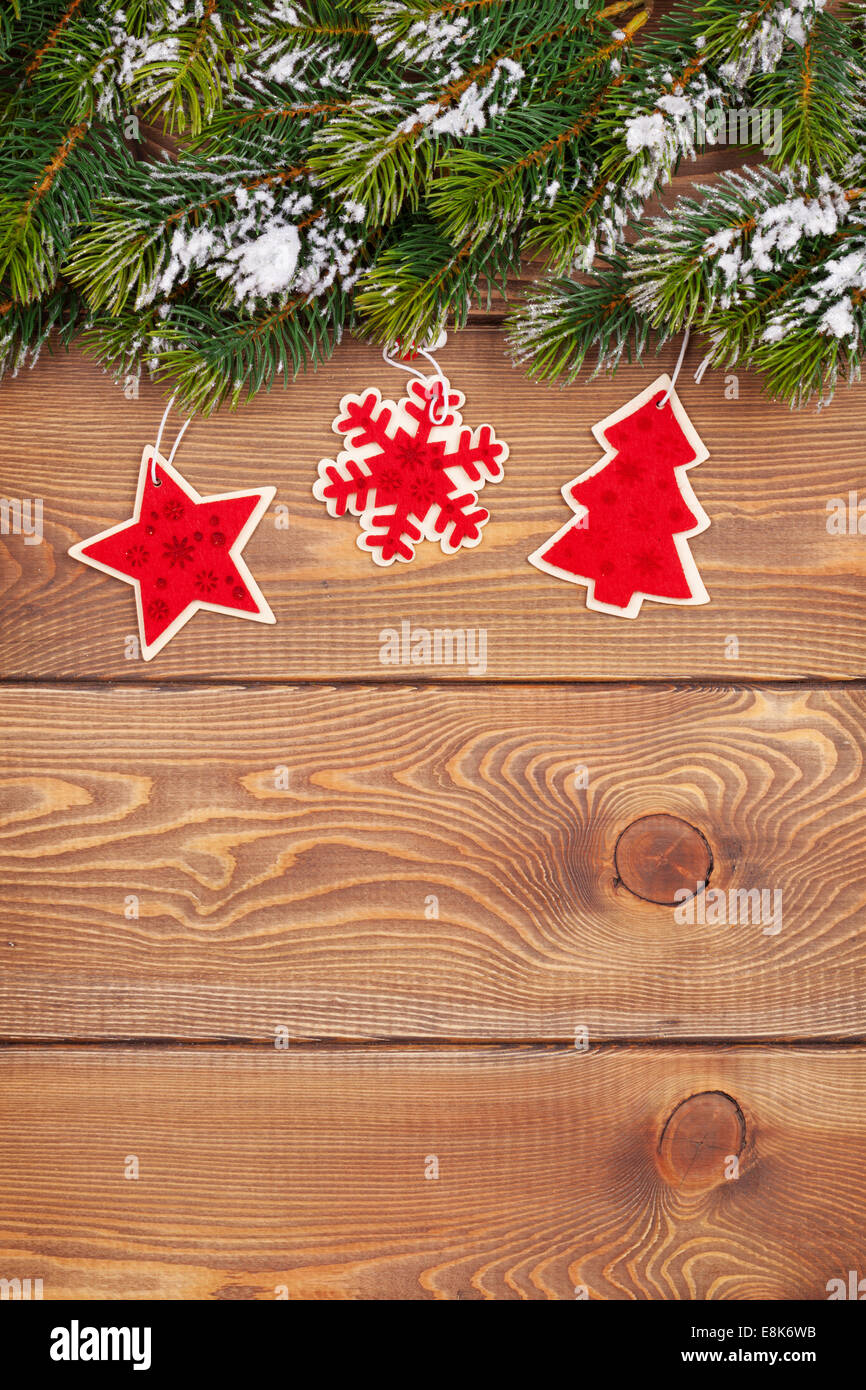 Weihnachten Tannenbaum mit Schnee und Urlaub Dekor auf rustikalem Holzbrett mit Textfreiraum Stockfoto