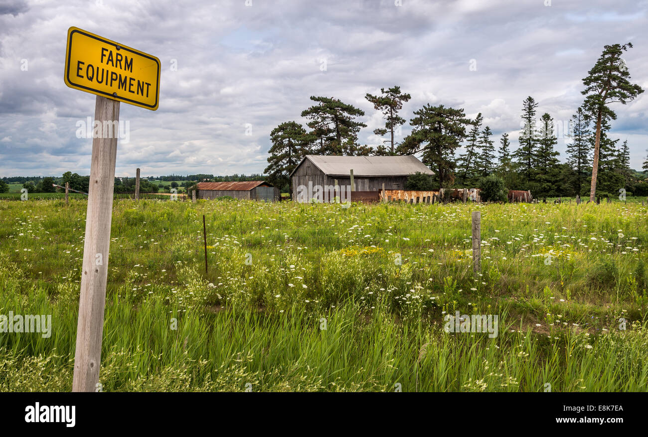 Landwirtschaftlichen Maschinen melden mit einer Scheune im Hintergrund. Stockfoto