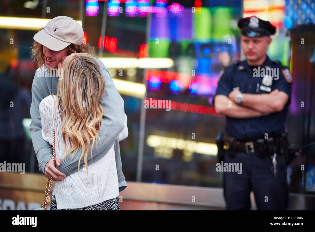 New York City Times Square NYC Polizist einen paar Kuss zu beobachten, wie er die Gegend patrouilliert Stockfoto