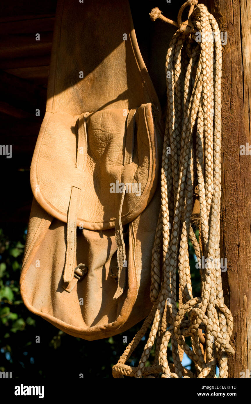 Satteltaschen und Seilen aufgehängt in einem Pferdestall in Sonne verwöhnten mediterranen Ambiente Stockfoto