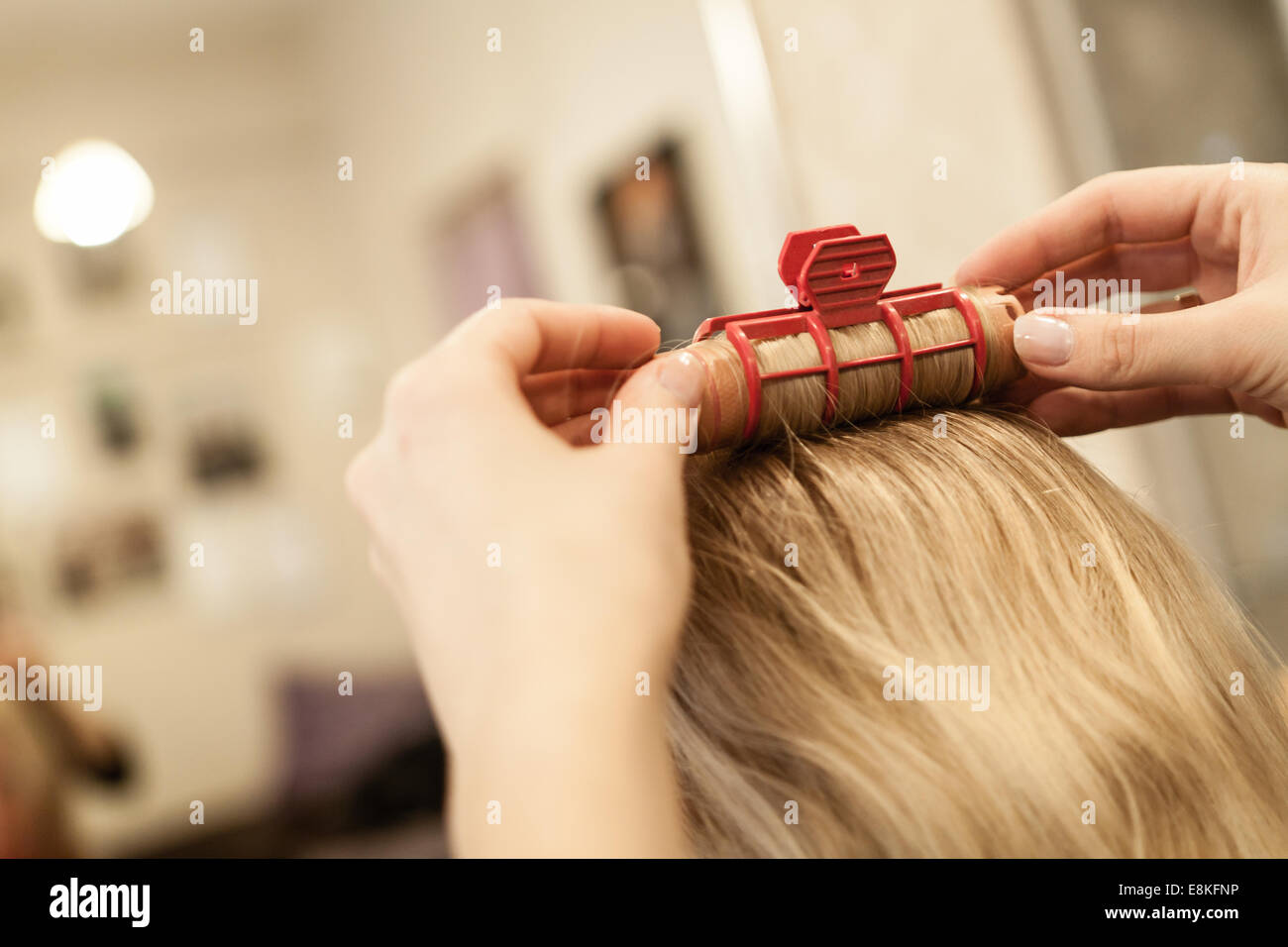 Kaukasische Mädchen bei Friseur-Service mit nassen Haaren und versuchen Roll Haar in locken mit Rollen, hintere Aufnahme hautnah Stockfoto