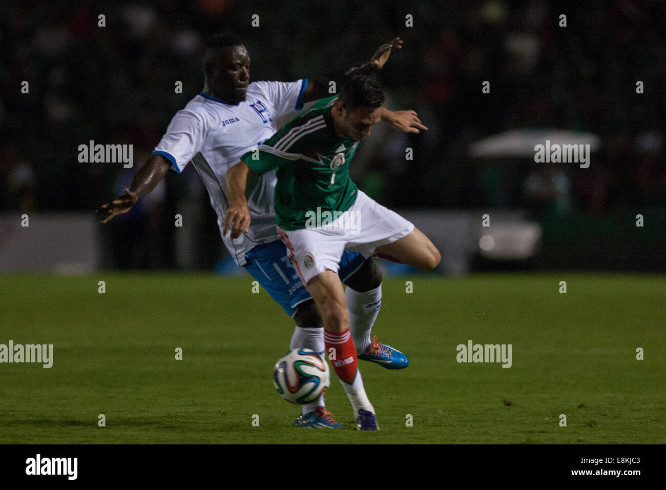 Tuxtla Gutierrez, Mexiko. 9. Oktober 2014. Mexikos Miguel Layun (R) wetteifert um den Ball mit Honduras Wilmer Crisanto (L) bei einem internationalen Freundschaftsspiel im Victor Manuel Reyna-Stadion in Tuxtla Gutiérrez, Chiapas, Mexiko, am 9. Oktober 2014 statt. © Pedro Mera/Xinhua/Alamy Live-Nachrichten Stockfoto