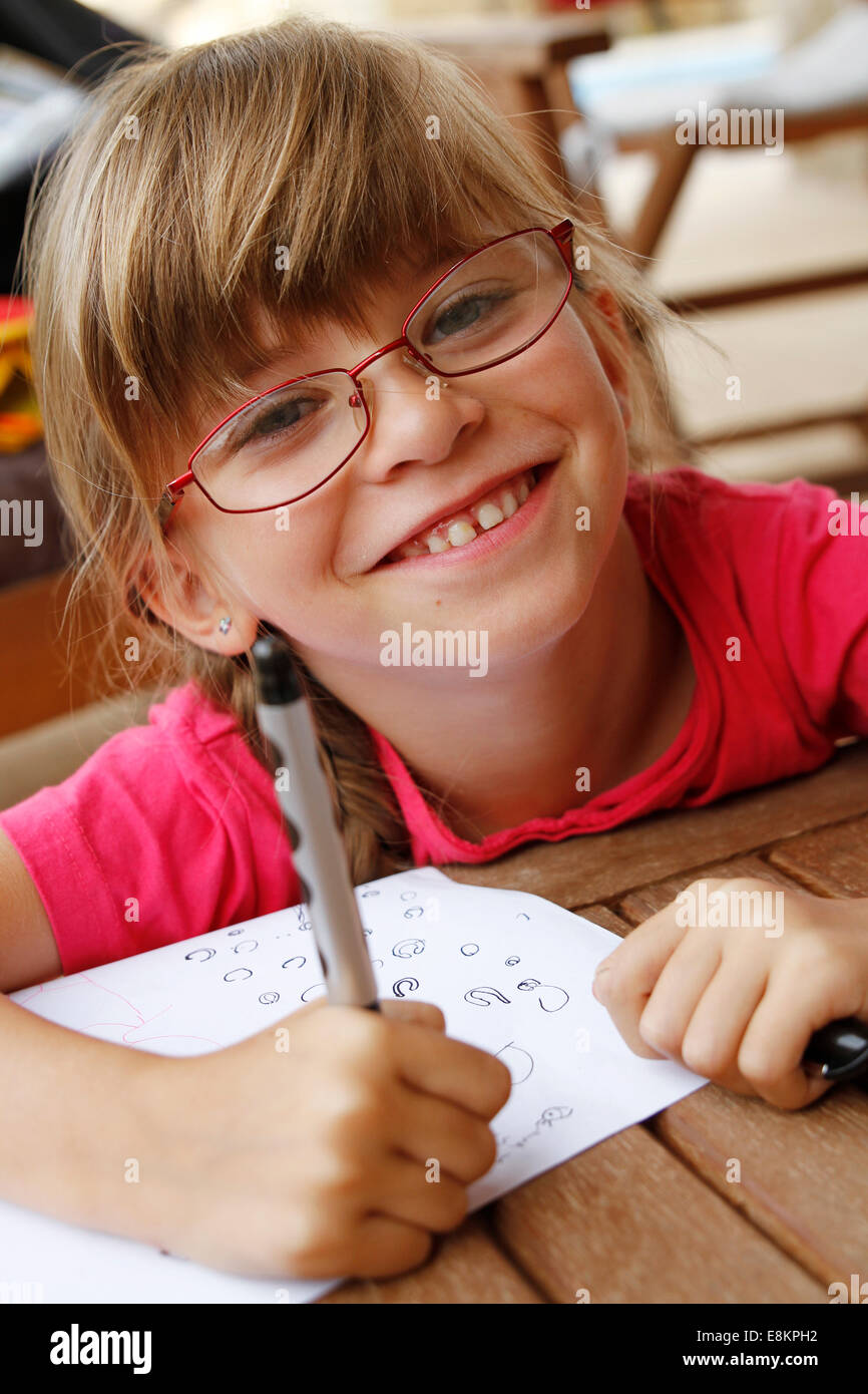 Eine 6-jährige Mädchen üben schreiben während der Ferien. Stockfoto