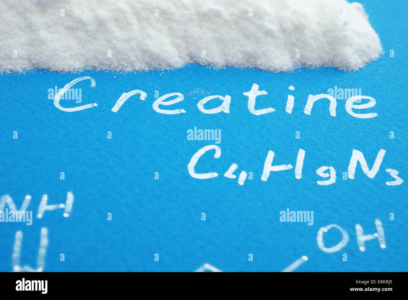 Сreatine Pulver mit chemische Formel des Kreatins auf blauem Papier Stockfoto