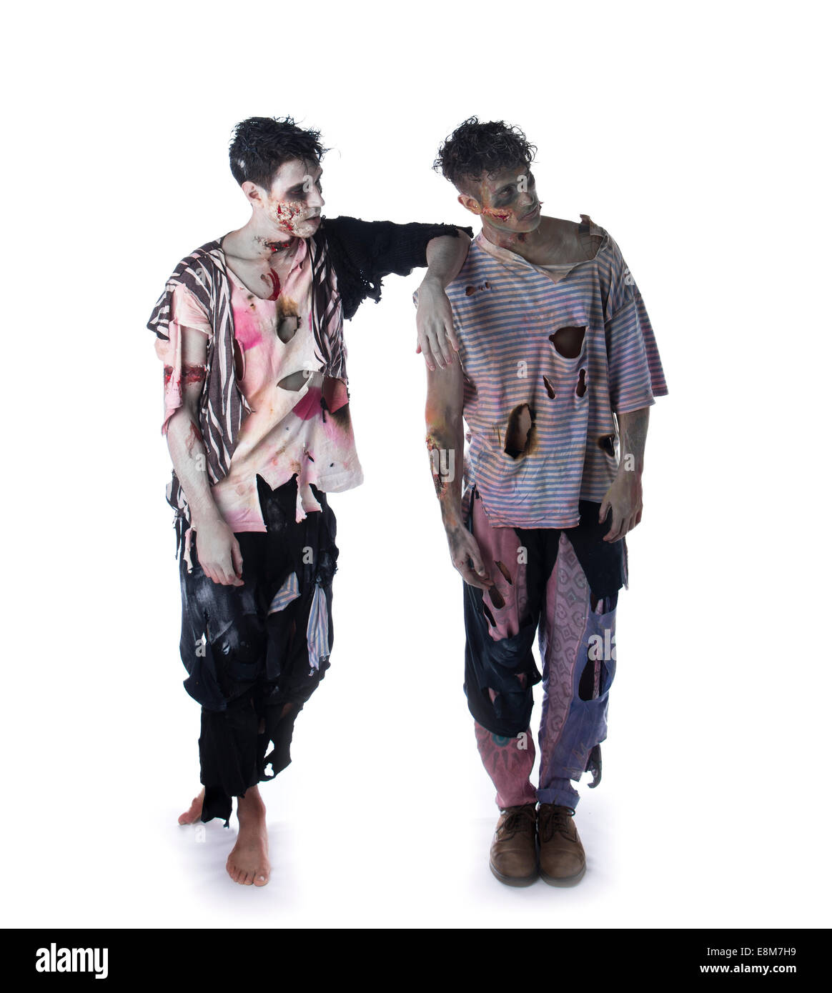 Zwei männliche Zombies auf weißem Hintergrund stehen, Ganzkörper erschossen, wegschauen. Halloween-Thema Stockfoto