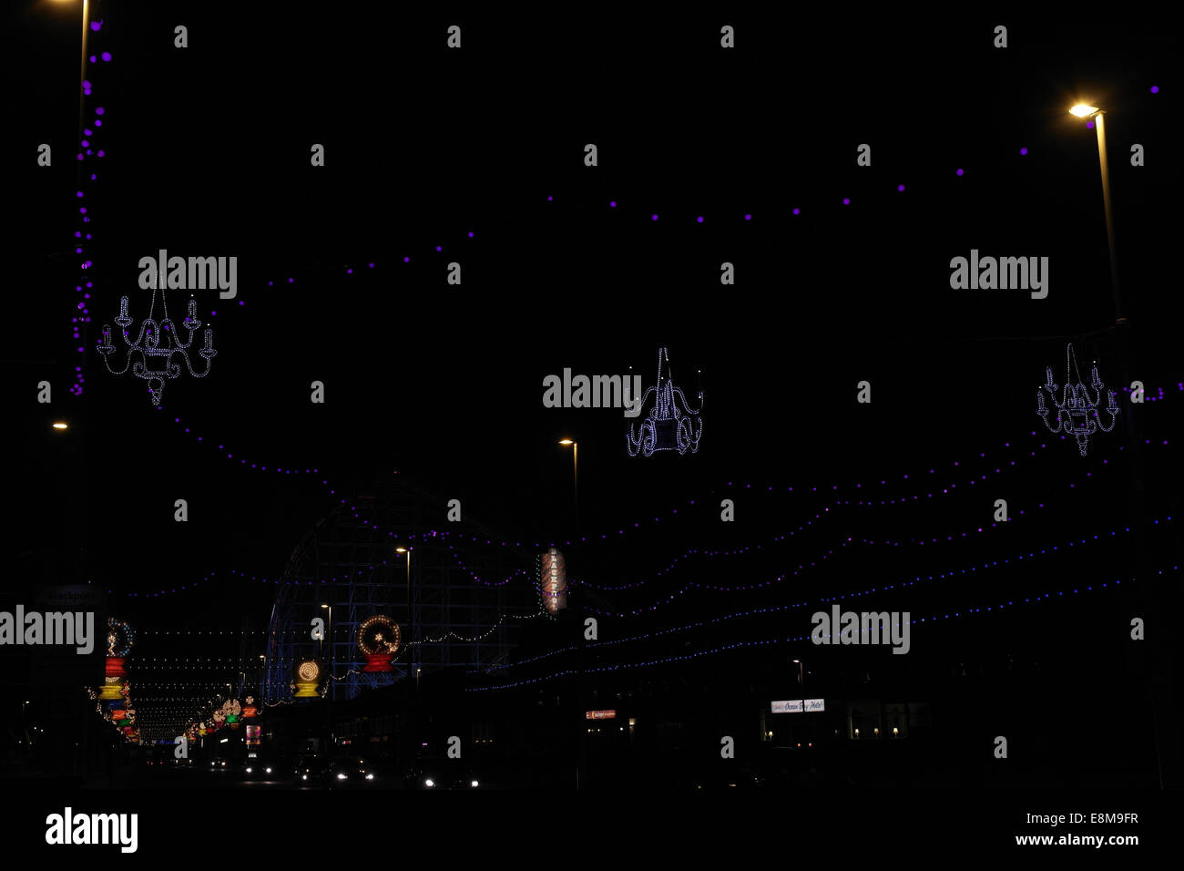Nacht-Ansicht drei blaue Kandelaber über South Shore Promenade in Richtung Orbs und Pleasure Beach Big One, Blackpool Illuminations Stockfoto