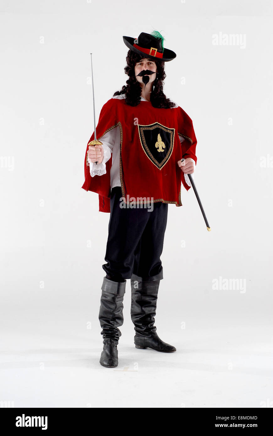 Mann im cavalier Stil historischen Kostüm, mit Schwert, Tunika, Hut und langen Haaren. Stockfoto