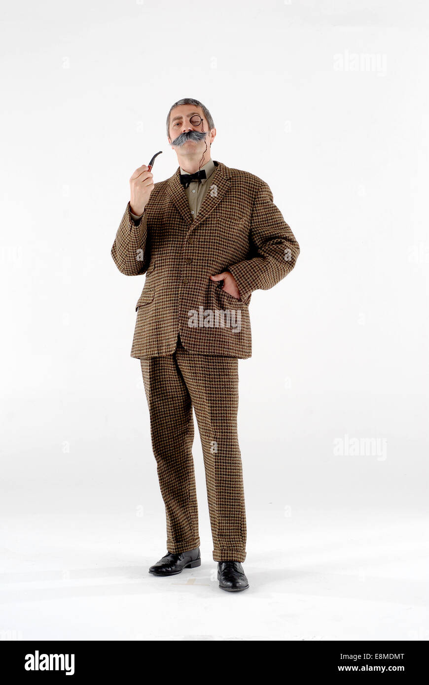 Mann in Komödie Kostüm gekleidet wie ein viktorianischer Gentleman mit Smoking-Jacke, Rohr, großen Schnurrbart und Monokel. Stockfoto