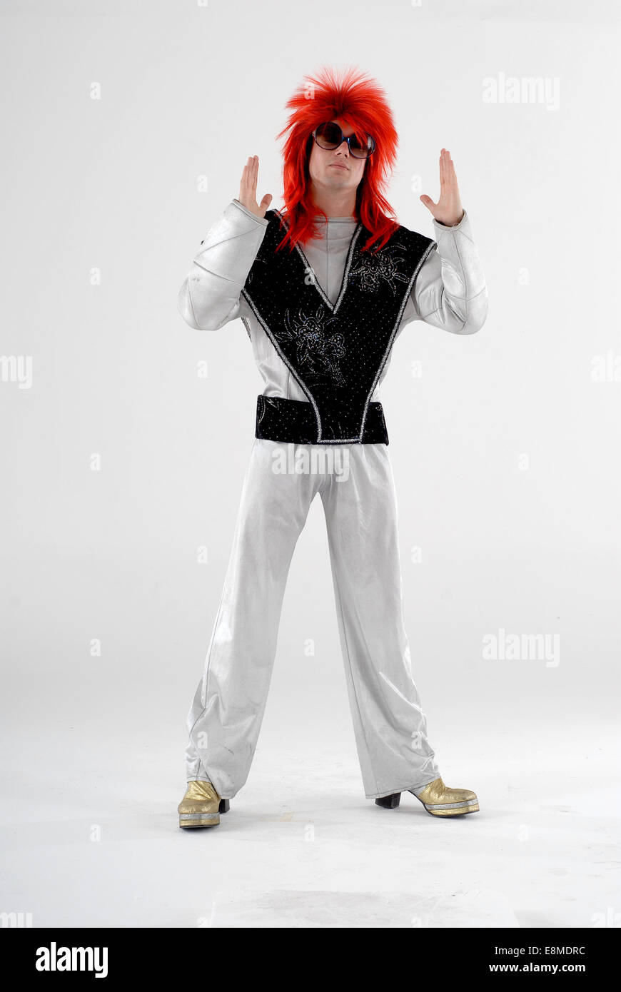 Mann verkleidet, Komödie Kostüm als ziggy Stardust David Bowie, Weltraumzeitalter Charakter, mit glänzenden silbernen Anzug, Perücke & Plattformen Stockfoto