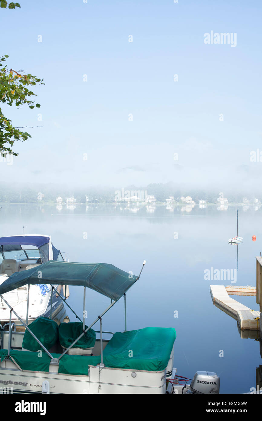 Boote sind am Pier auf Pontoosuc See in Pittsfield, Massachusetts an einem nebligen Morgen angedockt. Stockfoto