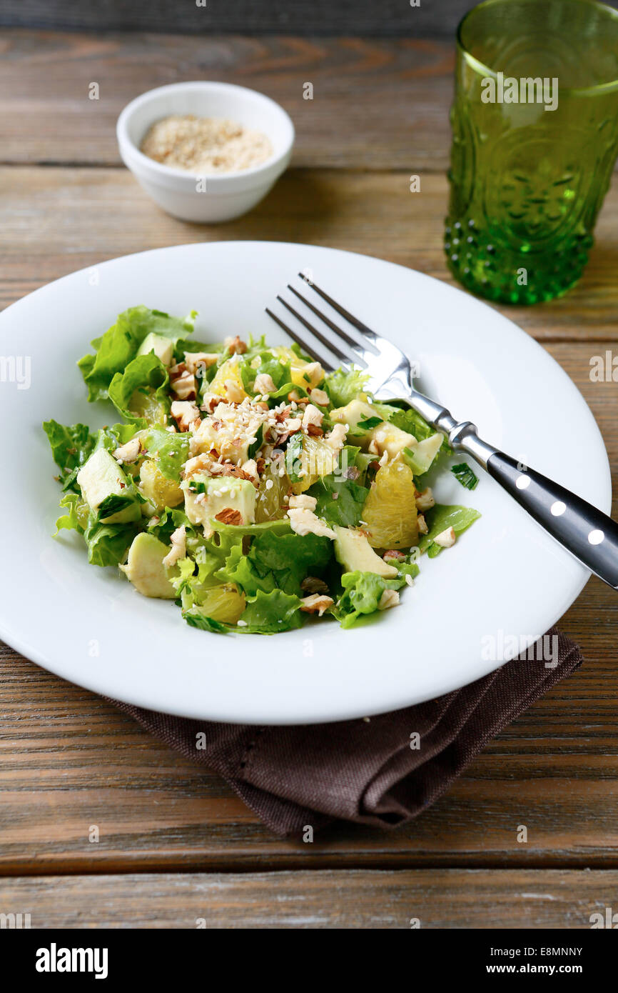 Salat mit Avocado, Salat, Orange und Nüssen auf einer Schüssel, leckeres Essen Stockfoto