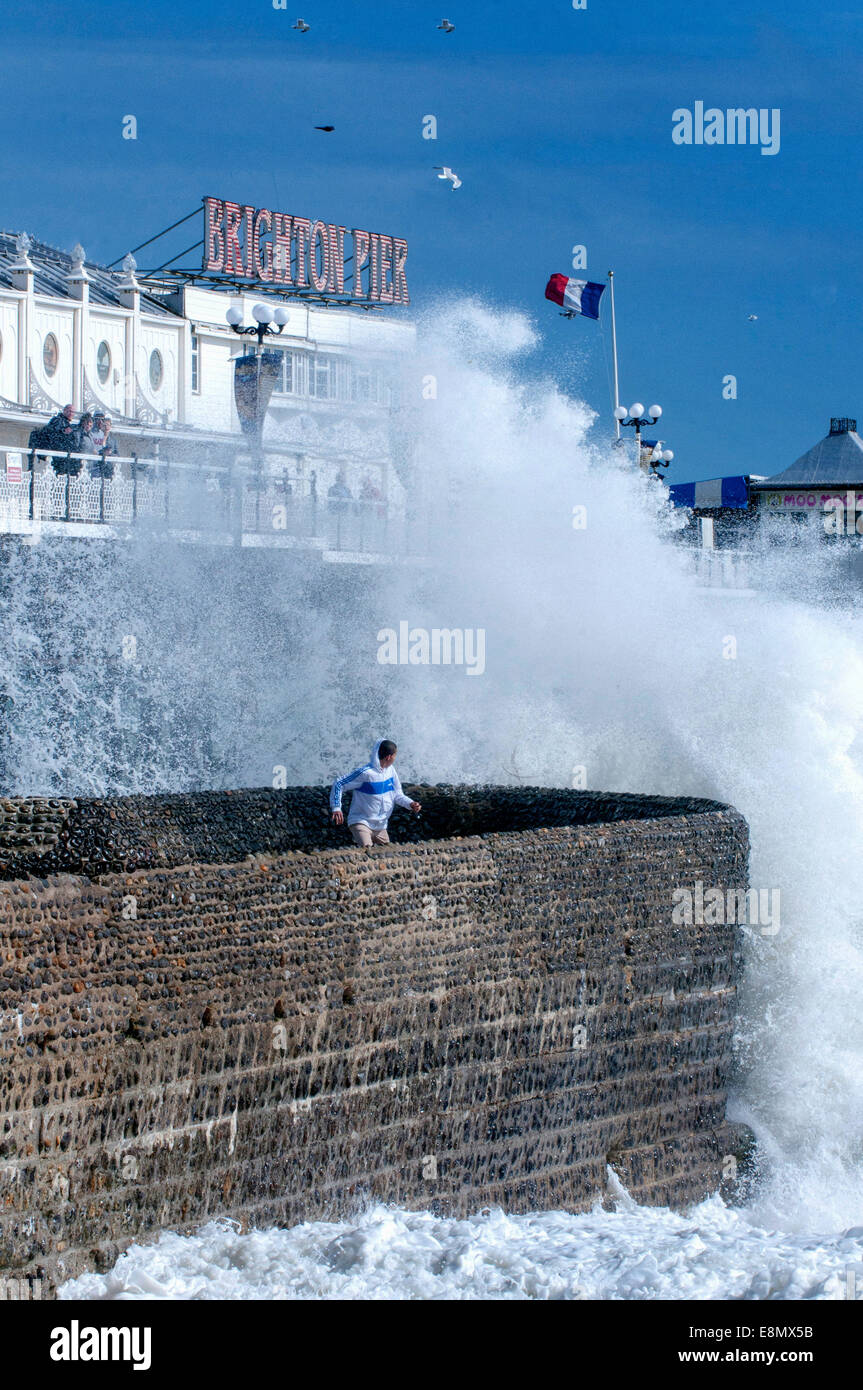 Menschen spielen in der Nähe brechenden Wellen auf Brighton Seafront. Stockfoto