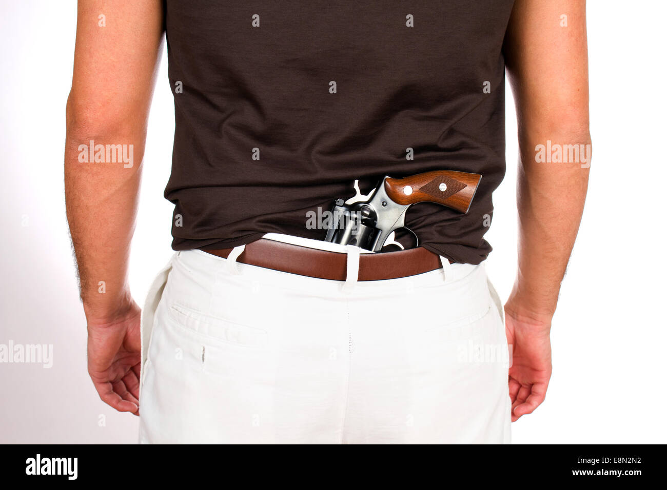 Mann mit Revolver hat die Waffe versteckt hinter seinem Rücken in der Hose. Stockfoto