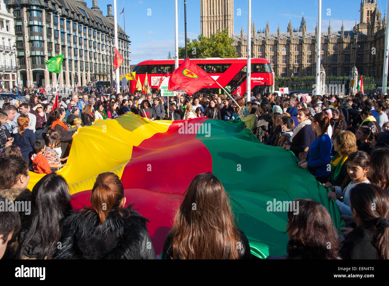 London, 11. Oktober 2014. Tausende von Demonstranten aus der UK kurdische Gemeinschaft demonstrieren gegen die Verzögerung bei der Unterstützung der Menschen in der syrischen Stadt Kobane in ihrem Kampf gegen den is in London. Sie beschuldigen auch Türkei, mit denen die Kurden einen lang andauernden Aufstand des Abstellgleises mit den islamischen Staat hatte durch Nichtstun um Kurden in Kobane helfen. Bild: Eine riesige Fahne wabert wie Frauen und Kinder skandieren Parolen. Bildnachweis: Paul Davey/Alamy Live-Nachrichten Stockfoto