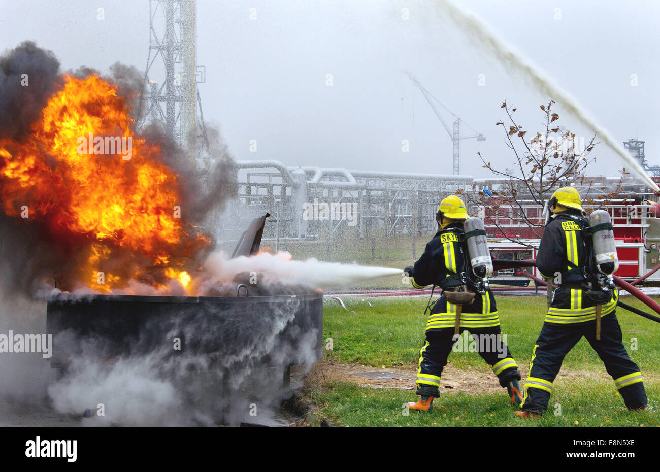 Zwei Feuerwehrleute kämpfen eine große Flamme-Feuer. Stockfoto