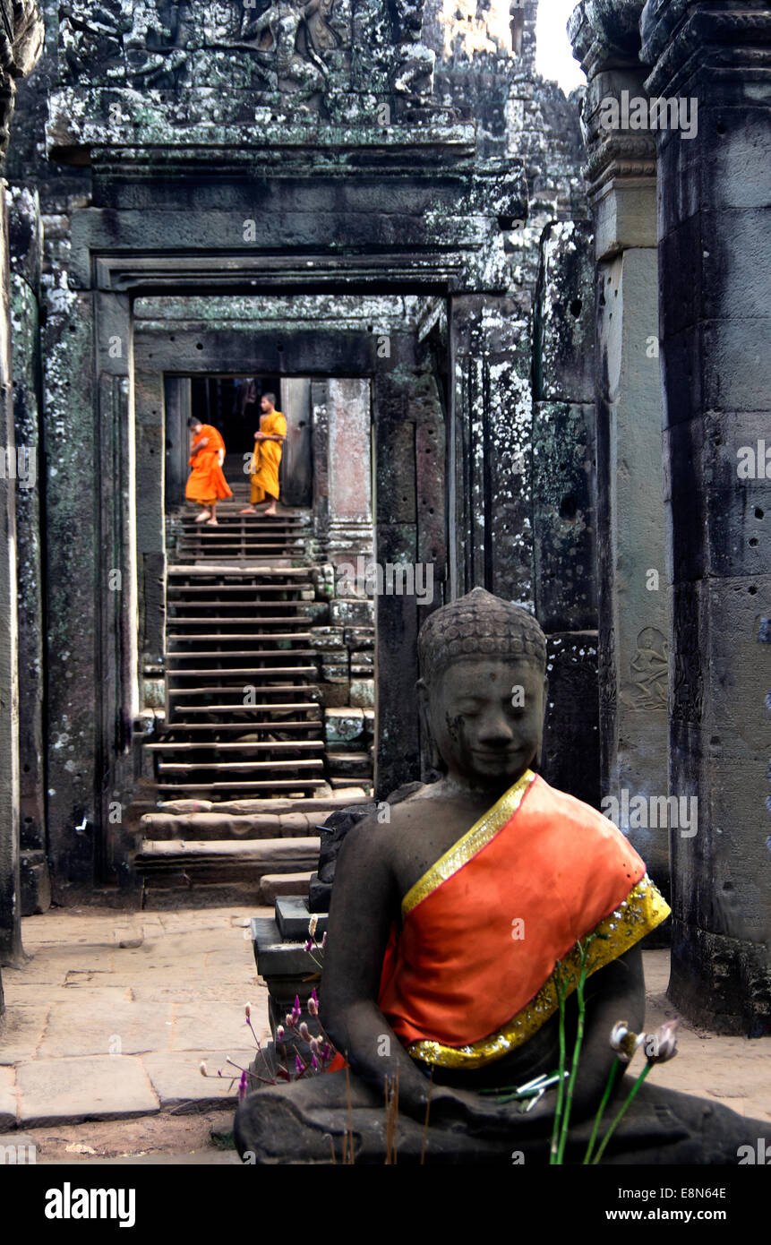 Bayon Tempel, Angkor Thom, Treppen, zwei junge Mönche hinunterklettern, verziert Gott im Vordergrund Stockfoto