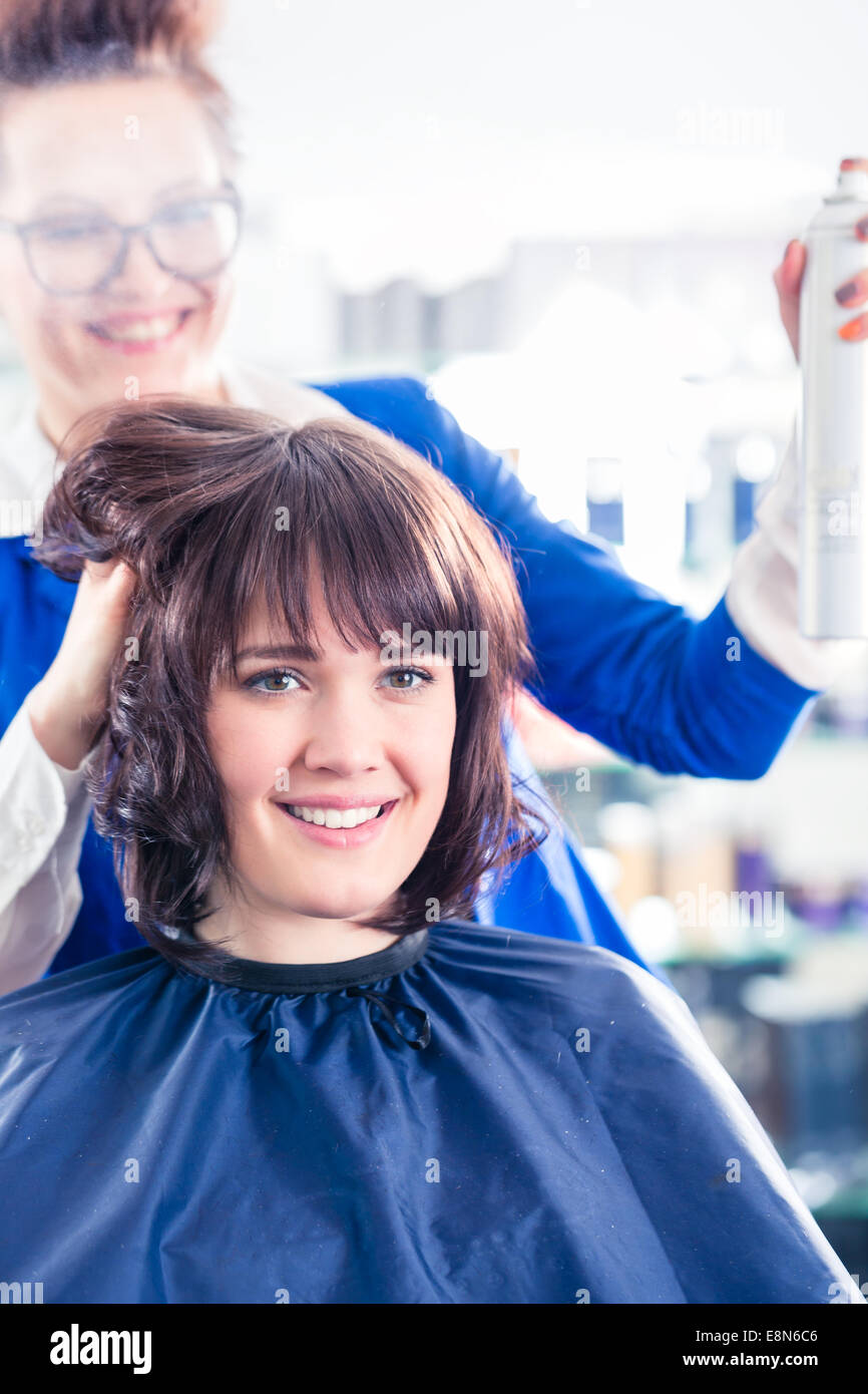 Weibliche Frisur geben Frauen Hairstyling mit Haarspray im Friseur-shop Stockfoto