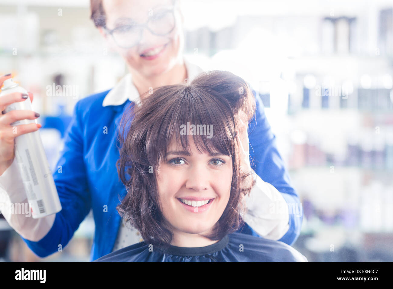 Weibliche Frisur geben Frauen Hairstyling mit Haarspray im Friseur-shop Stockfoto
