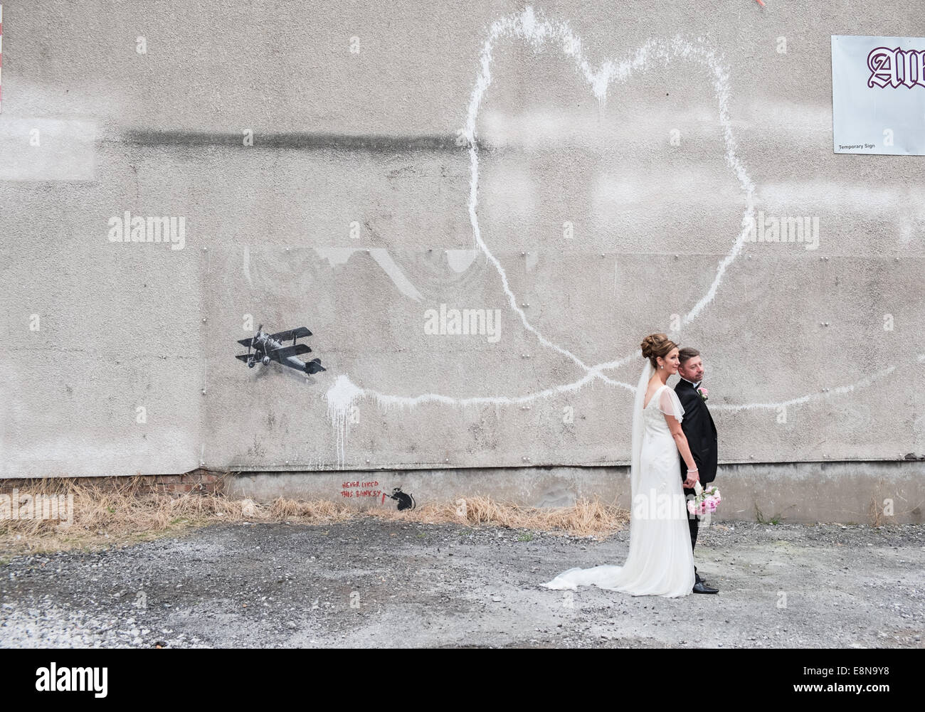 Hochzeit Bilder/Fotos von ein paar Vor einem Herzförmigen Vapor Trail aus bi-Ebene. Banksy, grafitti, Kunst, Liebe, Flugzeug, Liverpool, Stockfoto