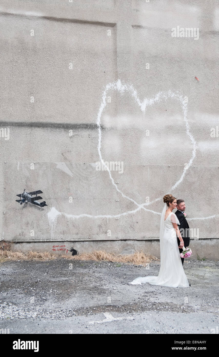 Hochzeit Bilder/Fotos von ein paar Vor einem Herzförmigen Vapor Trail aus bi-Ebene. Banksy, grafitti, Kunst, Liebe, Flugzeug, Liverpool, Stockfoto