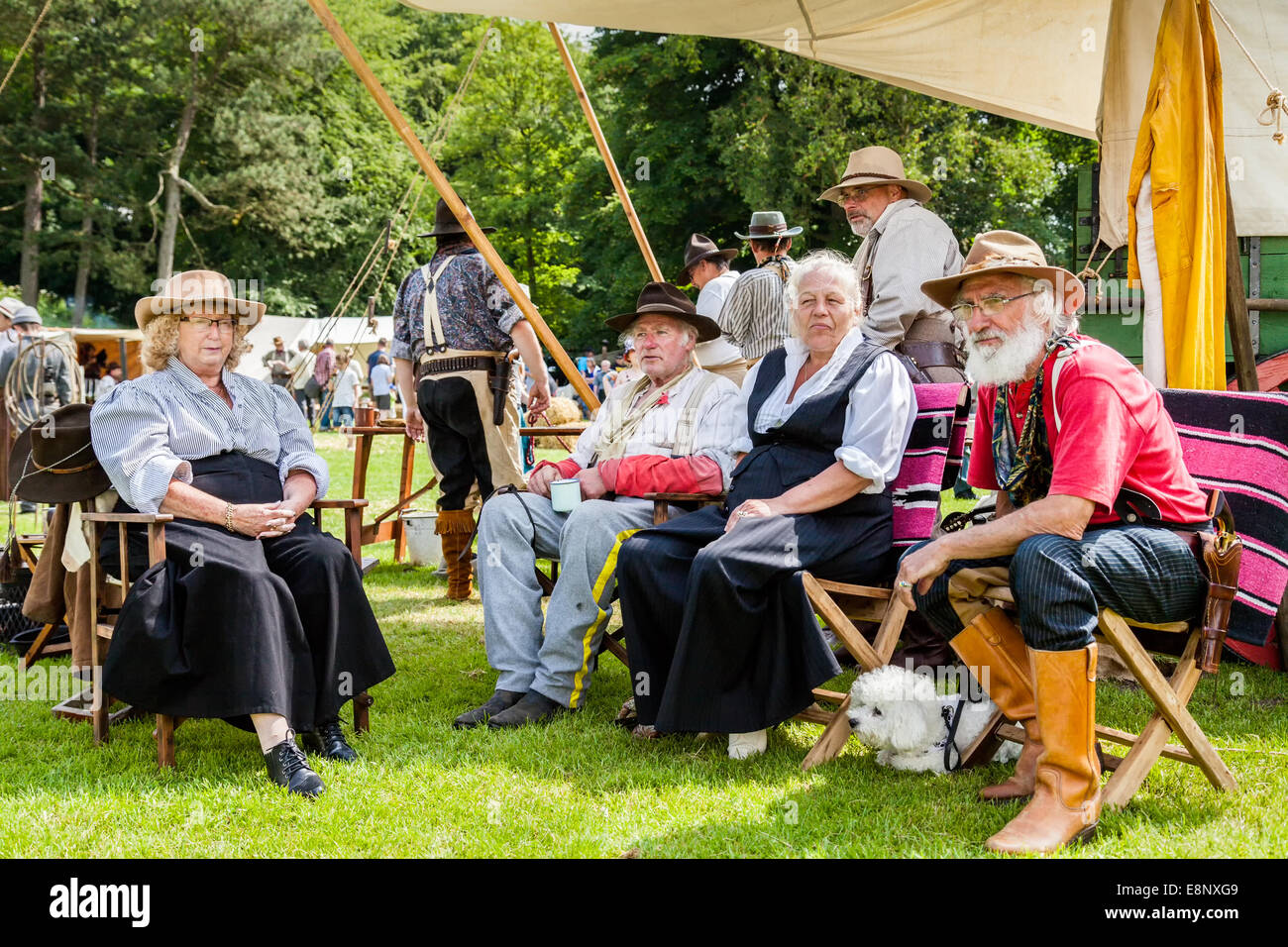Lauch England UK 21. Juni 2014. Eine Gruppe von Männern und Frauen in ein offenes Feld Campingplatz in USA Cowboy Outfits gekleidet sitzen. Stockfoto