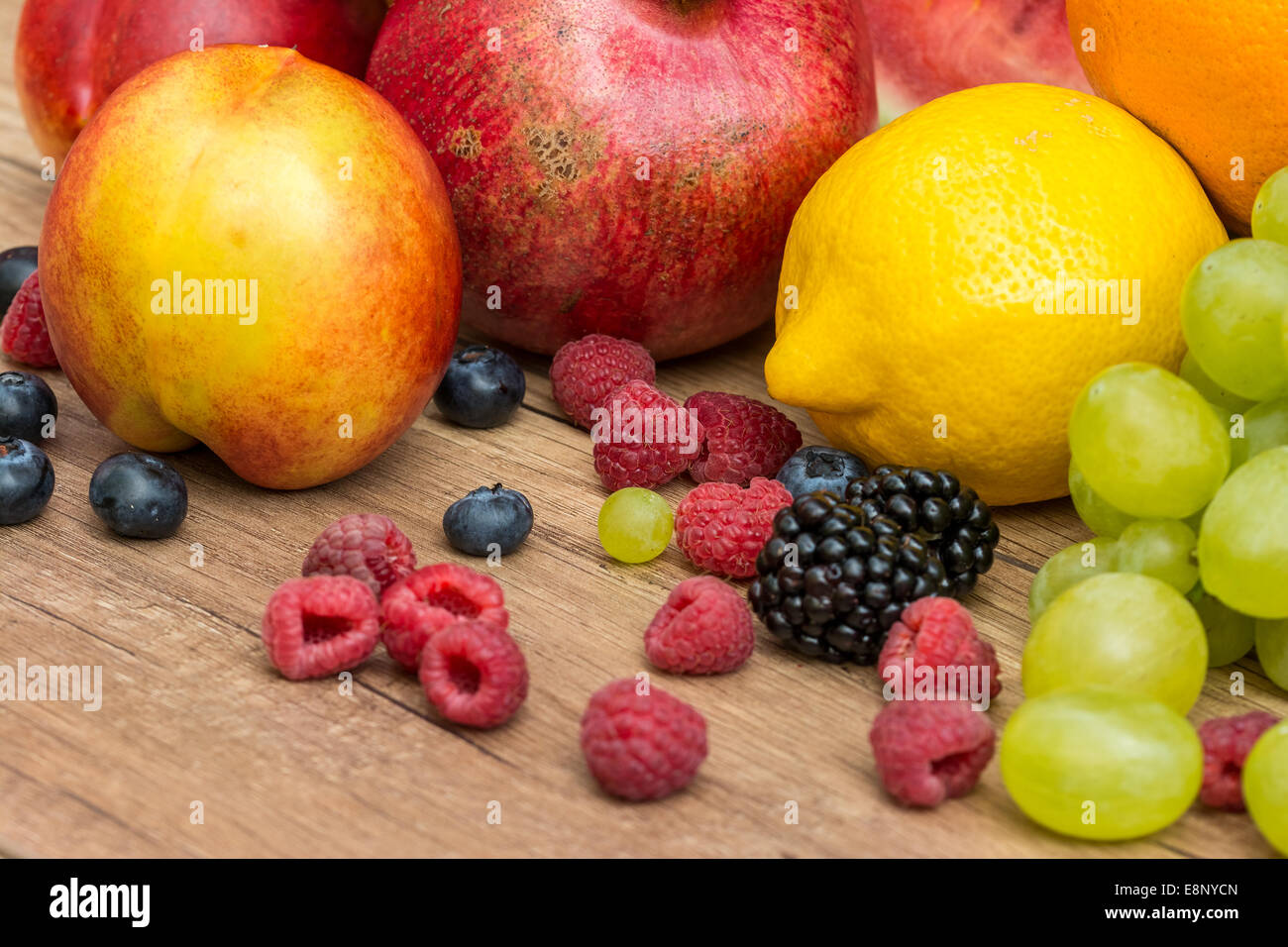 Zitrone, Trauben und Beeren Sommerfrüchte auf Holztisch Stockfoto