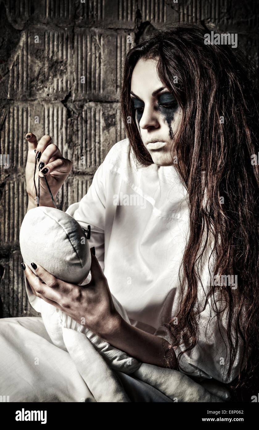 Horror-Szene: die seltsame verrücktes Mädchen mit Nadel in Händen und Mizzi Puppe Stockfoto