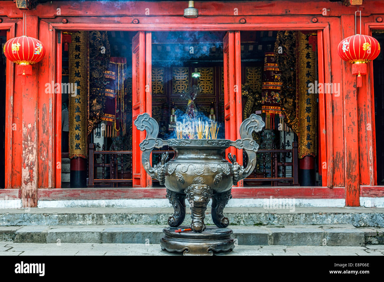 Räucherstäbchen Sie brennt vor dem roten Tempeleingang. Stockfoto