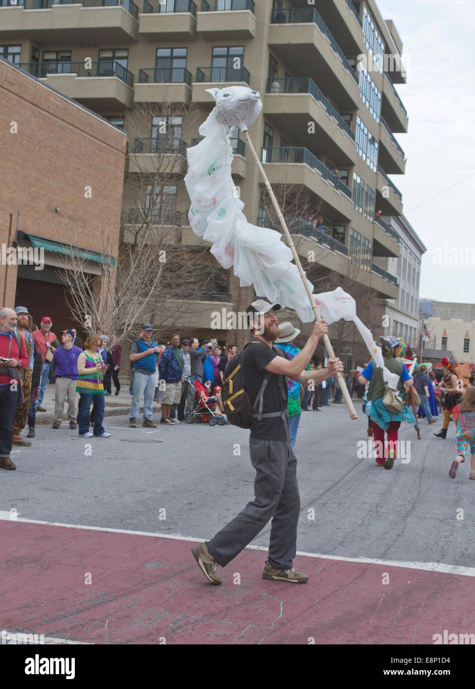 Ein Mann in eine Karneval Parade marschieren "Wellenlinien" eine künstlerische, fließenden Wolf Kopf Marionette aus Einweg-Plastiktüten geschaffen Stockfoto