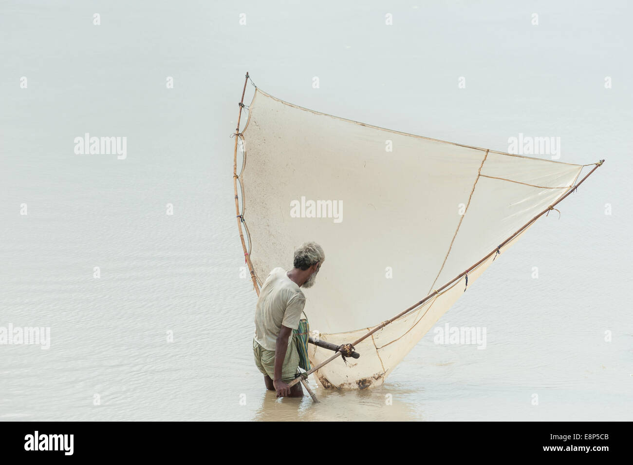 Fisher Mann fängt Fische im Fluss mit lokalen handgemachten Fischnetz Stockfoto