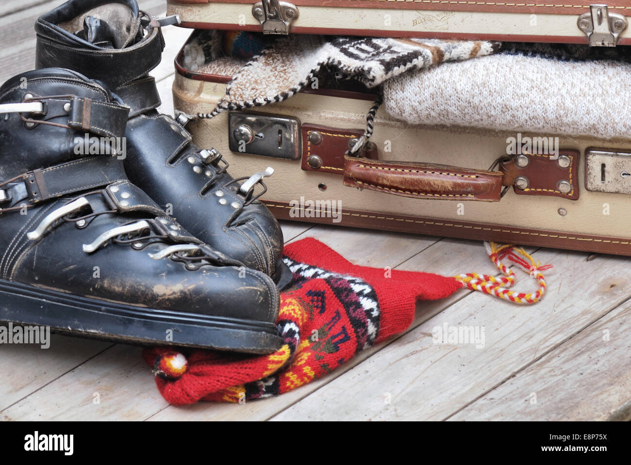 kleine offene Koffer voller warme Kleidung mit alten Skischuhe Stockfoto