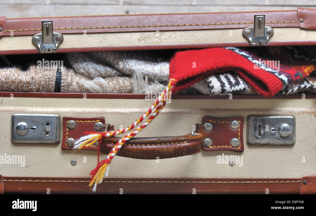 kleine Koffer gefüllt angelehnt und warme Kleidung Stockfoto