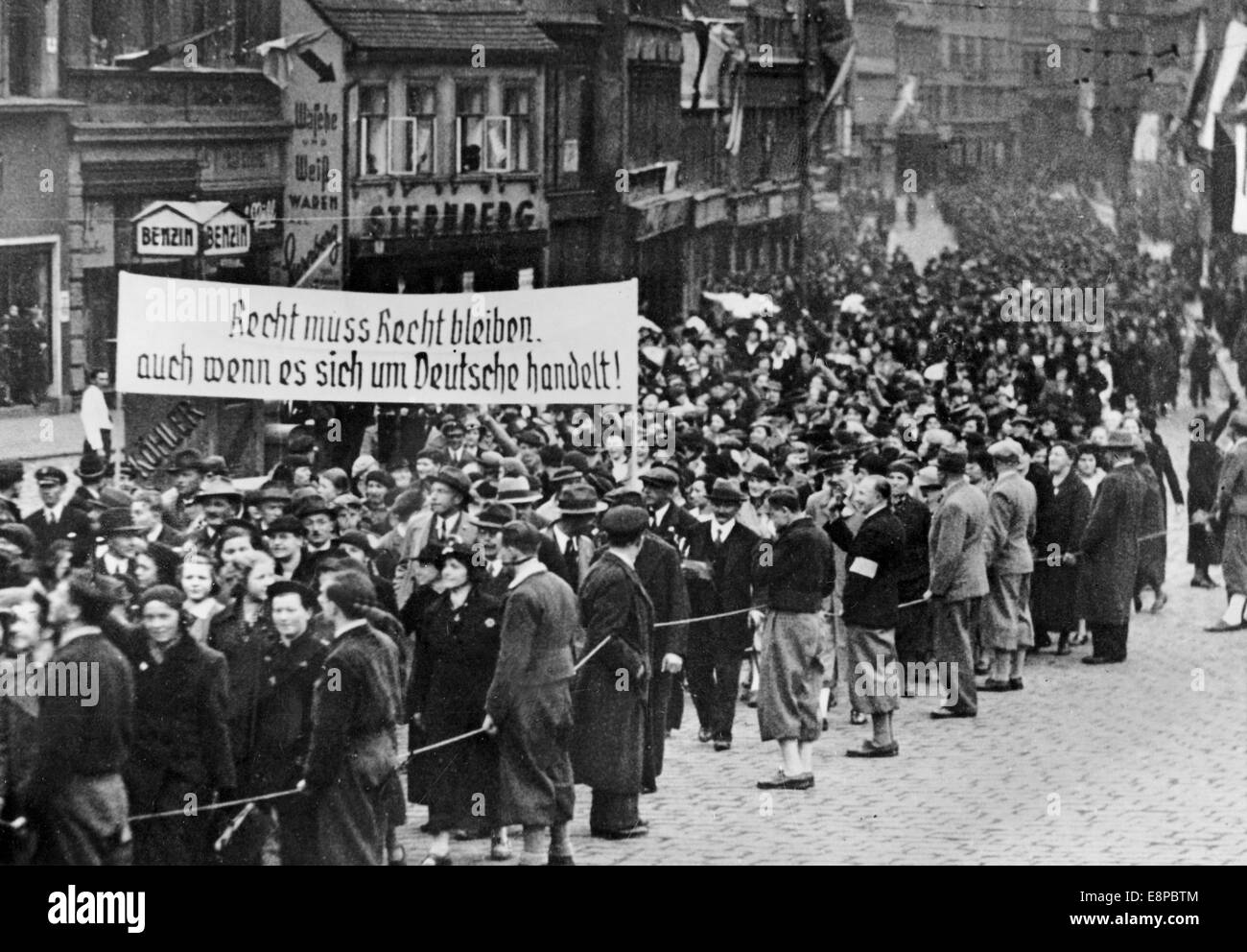 Gesetze müssen auch dann befolgt werden, wenn es um Deutsche geht, steht auf einem Banner während einer Kundgebung der Sudetendeutschen in Teplitz-Schoenau, Tschechoslowakei, 01. Mai 1938. Propganda-Text! Aus einem Nazi-Nachrichtenbericht vom 01. Mai 1938 auf der Rückseite des Fotos: 'Die Sudetendeutschen feiern den 01. Mai. Die große Kundgebung der Sudetendeutschen in Tepiltz-Schoenau. Sudetendeutsche marschieren zum Marktplatz in Tepiltz-Schoenau, wo eine der größten Demonstrationen vom Mai 01 stattfand, wo Konrad Henlein sprach." Fotoarchiv für Zeitgeschichte Stockfoto