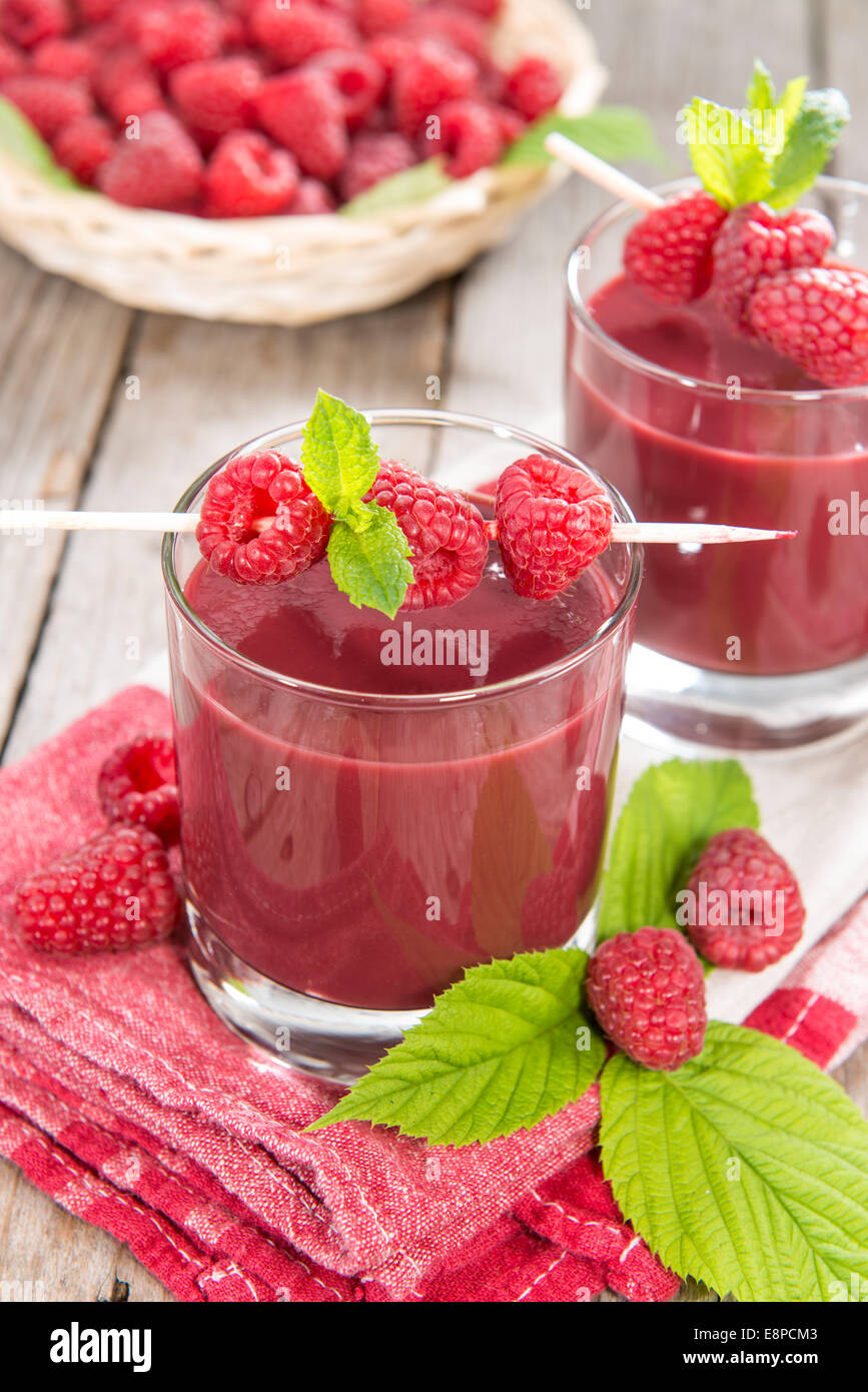 Glas mit hausgemachten Himbeer Saft und einige frische Früchte auf hölzernen Hintergrund Stockfoto