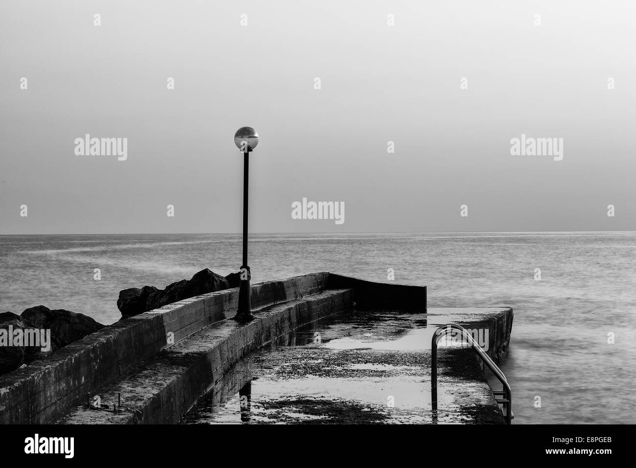 Schwarz-weiß-Foto von einem Steg im Meer Stockfoto
