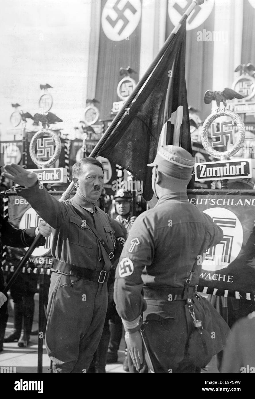 Nürnberger Rallye 1936 in Nürnberg – Neue Standards werden von Adolf Hitler während des großen Appells der Sturmtruppe (SA), Schutzstaffel (SS) und des Nationalen Sozialistischen Kfz-Korps (NSKK) in Luitpoldarena auf dem Nazi-Parteigelände mit der „Blutflagge“ (hinter Hitler) geweiht. Neue Standards von SA und SS wurden "geweiht", indem sie mit der "Blutflagge" verbunden wurden, die angeblich in der gescheiterten Bierhalle Putsch getragen wurde. (Qualitätsmängel aufgrund der historischen Bildkopie) Fotoarchiv für Zeitgeschichtee - KEIN KABELDIENST - Stockfoto