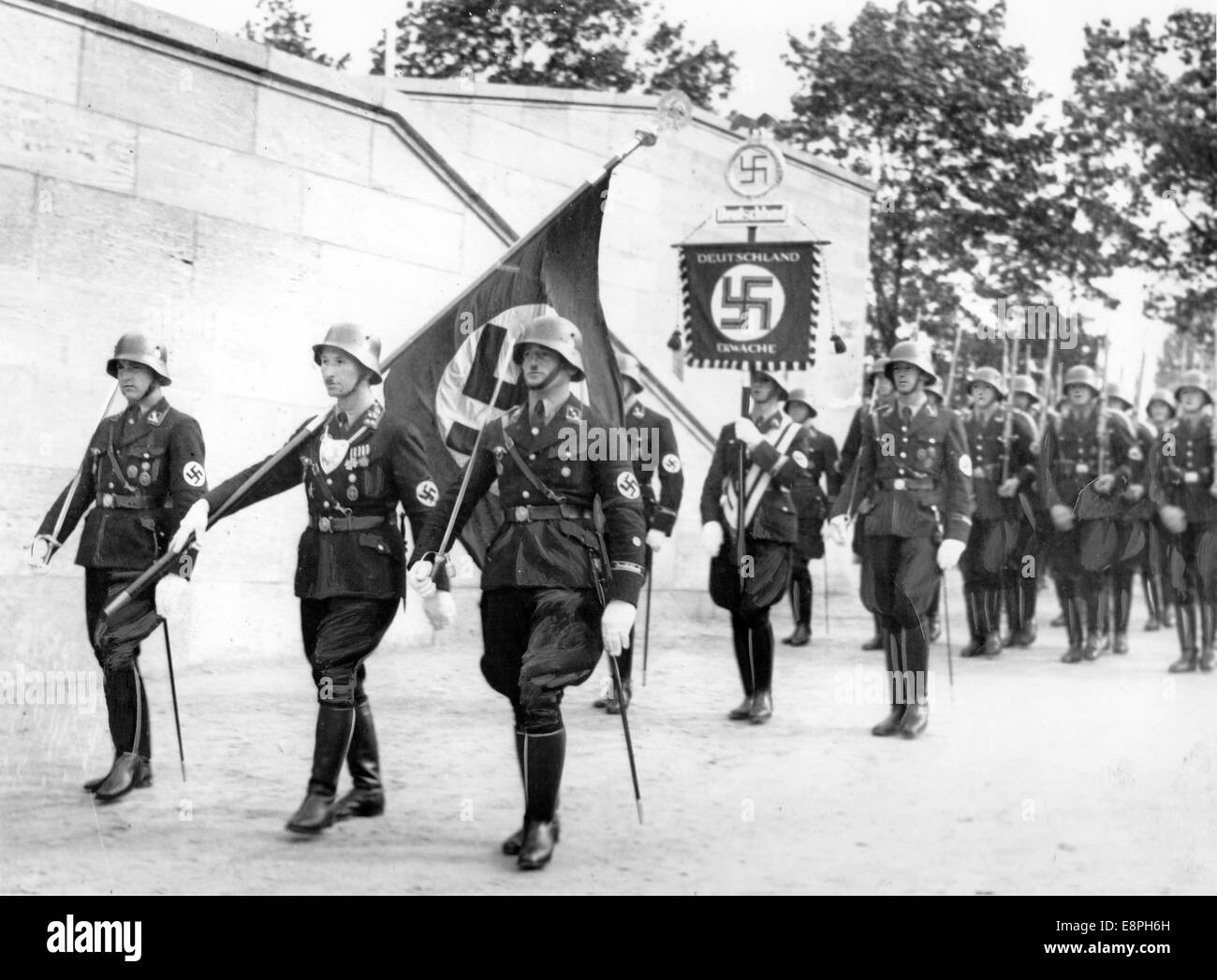 Nürnberg-Rallye-1937 in Nürnberg - Weihe der neuen Normen mit "Blut Flagge" von Adolf Hitler (nicht abgebildet) während der Appell der Sturmabteilung (SA), Schutzstaffel (SS), nationale sozialistische Motor-Korps (NSKK) und nationalen sozialistischen Flyer Corps (NSFK) am Puitpoldarena auf dem Gelände der Nazi-Partei Rallye, hier Eingang von der "Blut-Flagge" getragene "Träger des Blut-Flagge" Jakob Grimminger. Neue Maßstäbe der SA und SS wurden durch Berühren der Blut-Flagge, die angeblich in der gescheiterten Bier Hall Putsch durchgeführt wurde "geweiht" (Achtung: Originalkopie gewesen Retouc Stockfoto