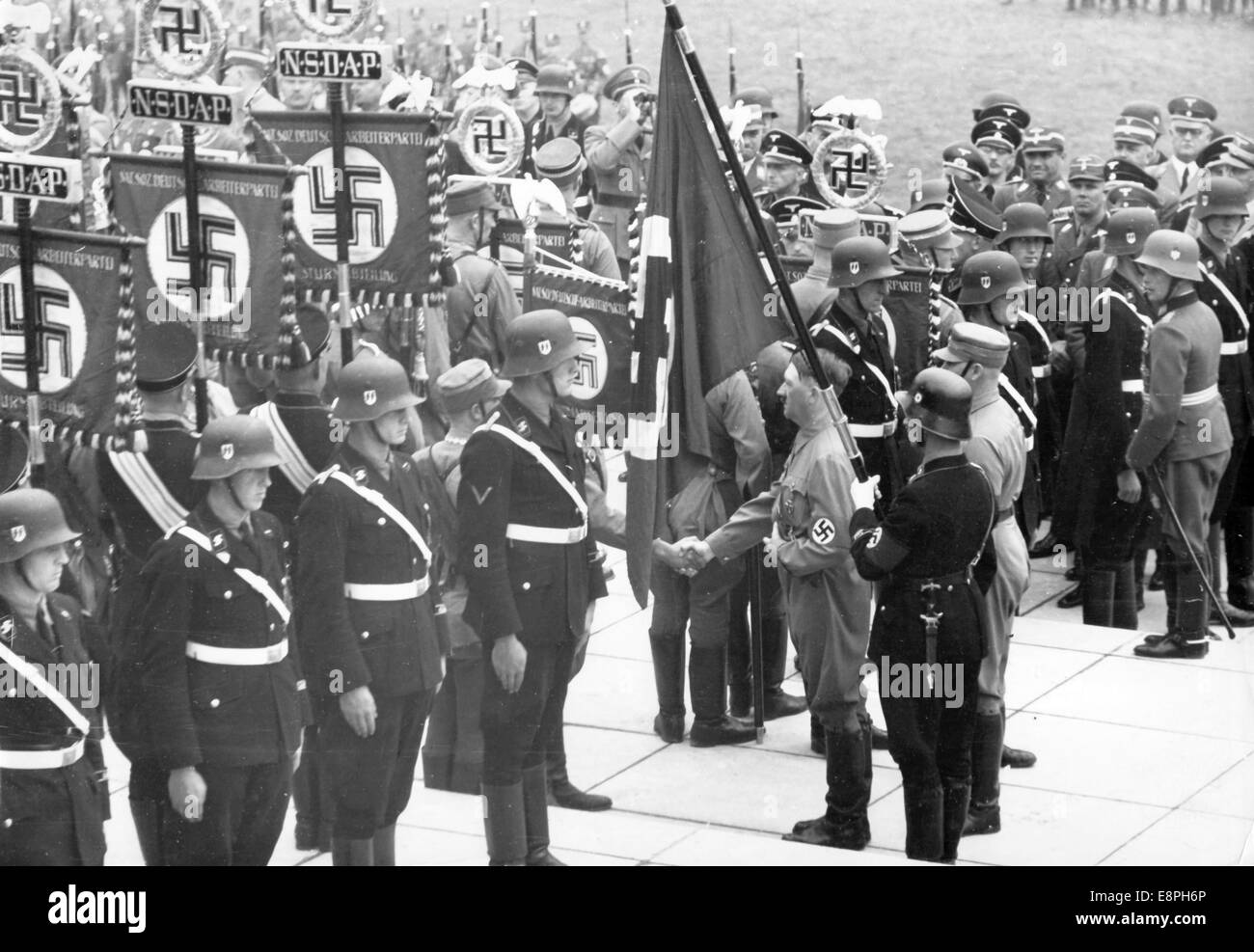 Nürnberger Rallye 1937 in Nürnberg - Konsecration neuer Standards mit der "Blutflagge" durch Adolf Hitler während des Appells der Sturmabteilung (SA), Schutzstaffel (SS), des Nationalen Sozialistischen Kfz-Korps (NSKK) und des Nationalen Sozialistischen Flyerkorps (NSFK) in Puitpoldarena auf dem Nazi-Parteigelände. Neue Standards von SA und SS wurden "geweiht", indem sie mit der "Blutflagge" verbunden wurden, die angeblich in der gescheiterten Bierhalle Putsch getragen wurde. (Qualitätsmängel aufgrund der historischen Bildkopie) Fotoarchiv für Zeitgeschichtee - KEIN KABELDIENST - Stockfoto