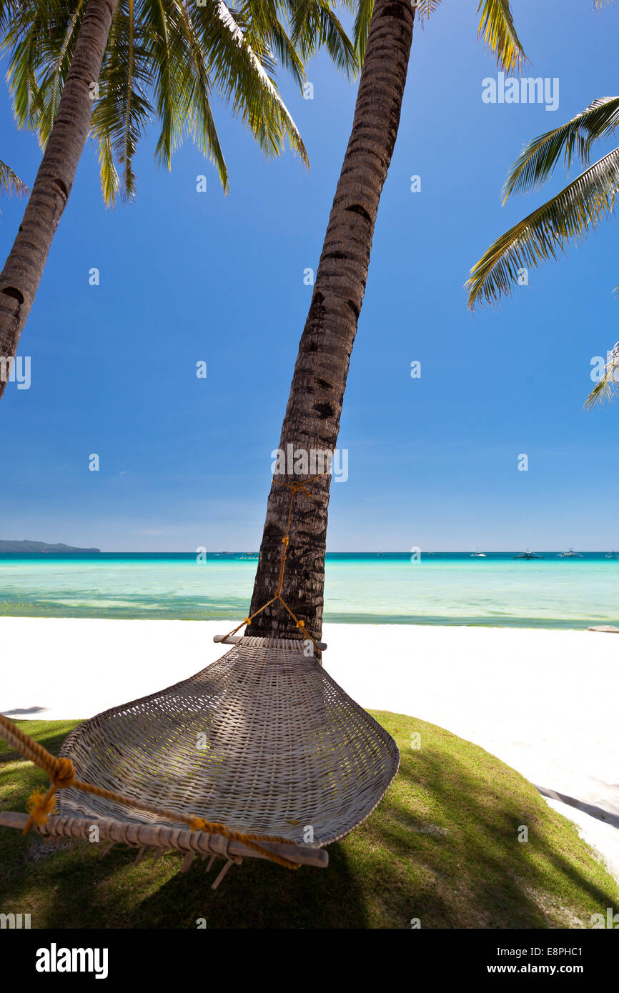 Leere Hängematte in der Nähe von Kokospalmen am weißen Strand Stockfoto