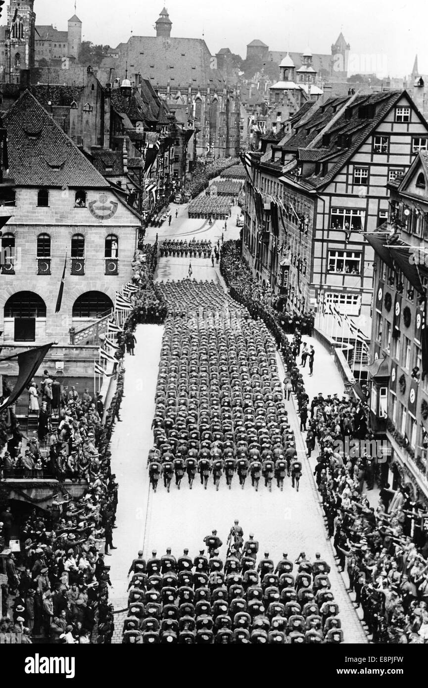 Nürnberger Rallye 1937 in Nürnberg - Mitglieder der SA (Sturmabteilung) marschieren über die Brücke Fleischbrücke vorbei an Häusern, die mit Kränzen und Hakenkreuzen geschmückt sind und mit dem Nazi-Salut begrüßt werden. Fotoarchiv für Zeitgeschichtee - KEINE ÜBERWEISUNG - Stockfoto