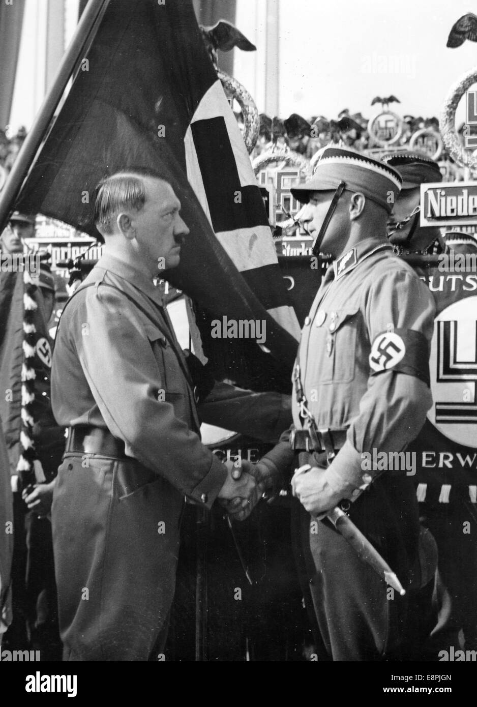 Nürnberger Rallye 1937 in Nürnberg – Adolf Hitler segnet neue Banner der SA (Sturmabteilung), SS (Schutzstaffel) und NSKK (Nationales sozialistisches Kfz-Korps) mit der "Blutflagge". Die „Blutflagge“ (hinter Hitler) wurde angeblich während der gescheiterten Bierhalle Putsch getragen. Fotoarchiv für Zeitgeschichtee – KEIN KABELDIENST – Stockfoto