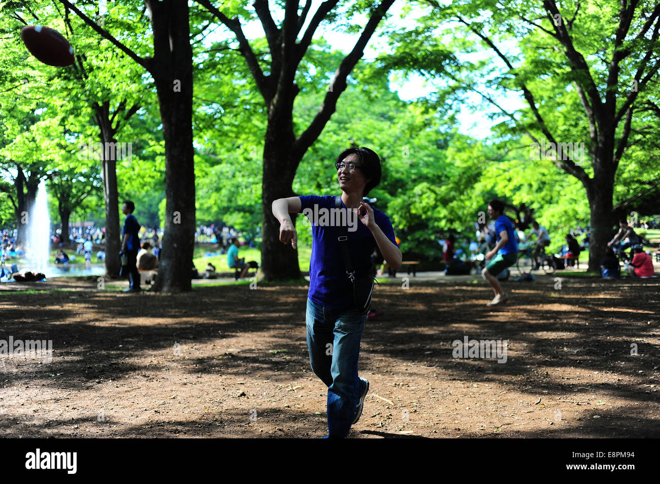 Japanischer Mann warf einen Fußball zu seinem Freund an der Yoyogi Park. Stockfoto
