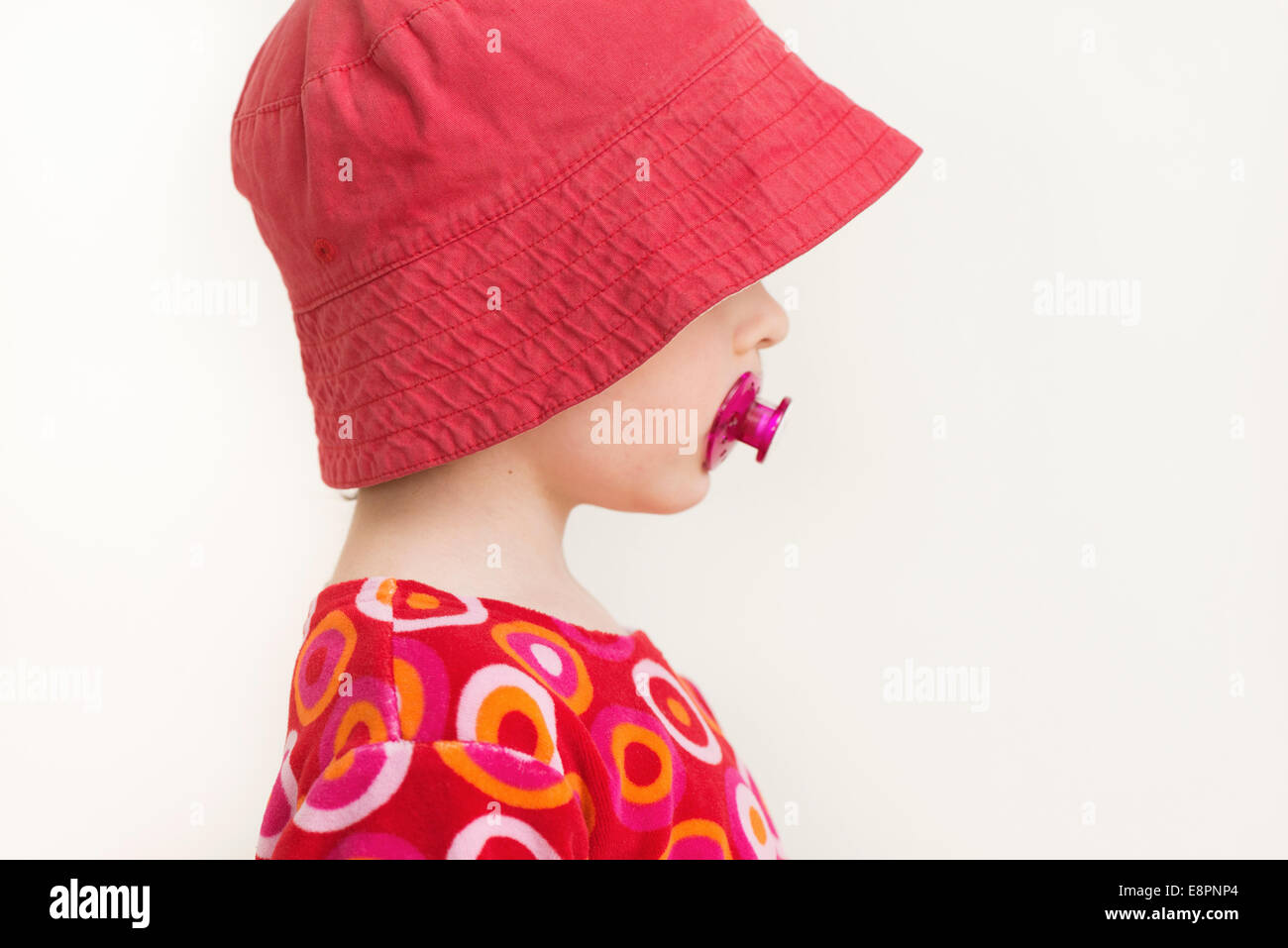 Profilbildnis von kleinen Mädchen mit rotem Hut und Schnuller Stockfoto
