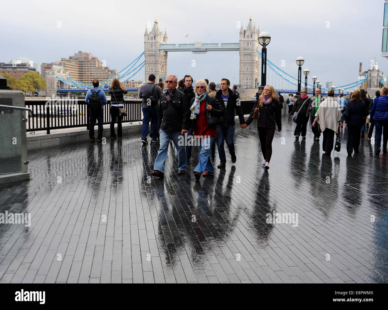 London-Southwark UK - Besucher zu Fuß entlang der Ufer des Flusses in der Nähe von Tower Bridge London im Regen UK Stockfoto